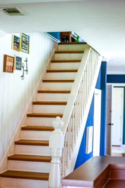 staircase featuring visible vents