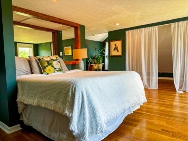 bedroom with vaulted ceiling and wood finished floors