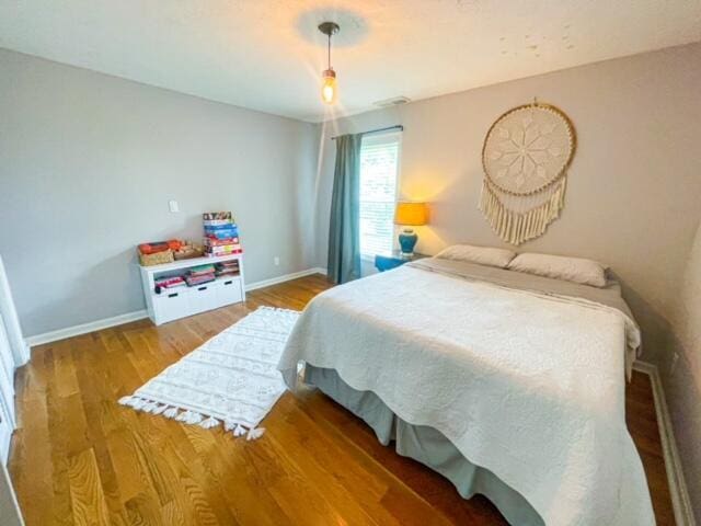 bedroom with wood finished floors and baseboards