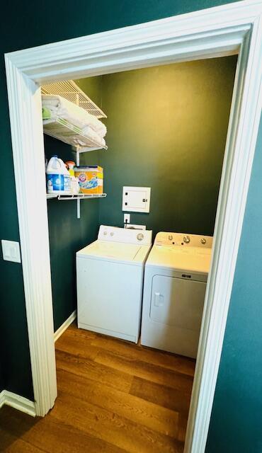 laundry room with laundry area, separate washer and dryer, and dark wood-type flooring