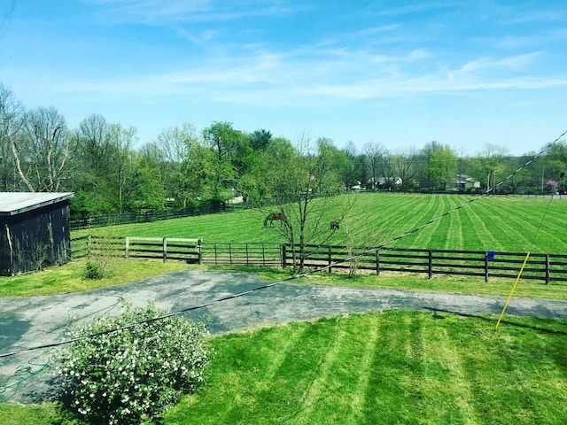 surrounding community featuring a yard, a rural view, and fence