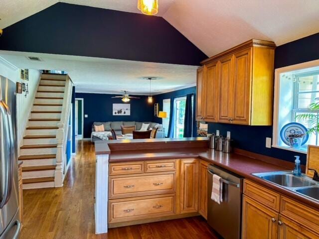 kitchen featuring dark wood-style floors, stainless steel appliances, a peninsula, and lofted ceiling