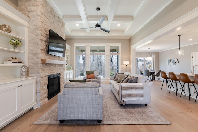 living room with ornamental molding, beamed ceiling, coffered ceiling, and light wood-style floors