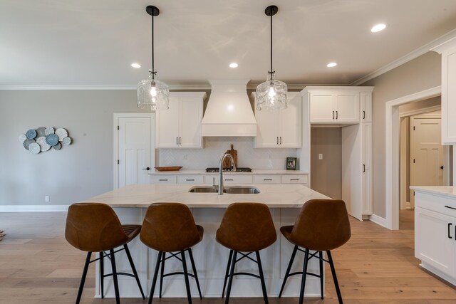 kitchen featuring tasteful backsplash, white cabinetry, ornamental molding, and custom exhaust hood