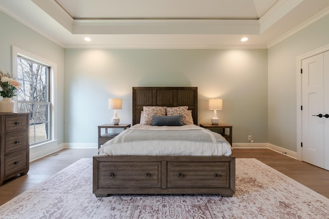 bedroom with recessed lighting, multiple windows, baseboards, and wood finished floors