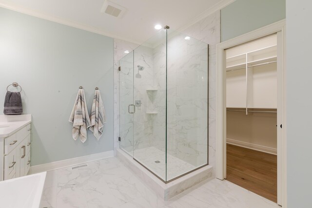 full bath featuring crown molding, marble finish floor, a marble finish shower, and baseboards