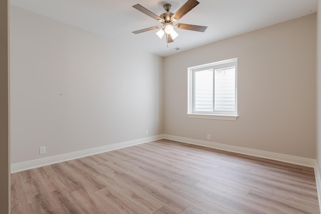 empty room with a ceiling fan, light wood-type flooring, visible vents, and baseboards