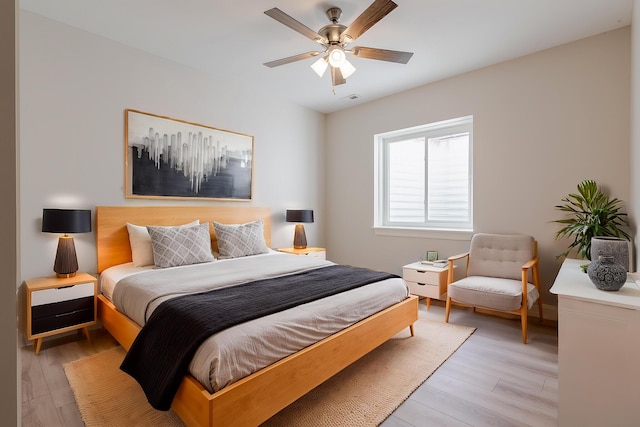 bedroom featuring light wood-style flooring, visible vents, and ceiling fan