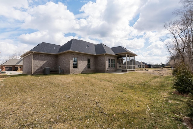 back of house with a yard, roof with shingles, and brick siding