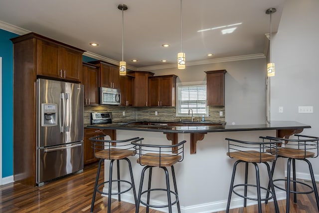 kitchen featuring dark countertops, appliances with stainless steel finishes, dark wood-style flooring, a sink, and backsplash