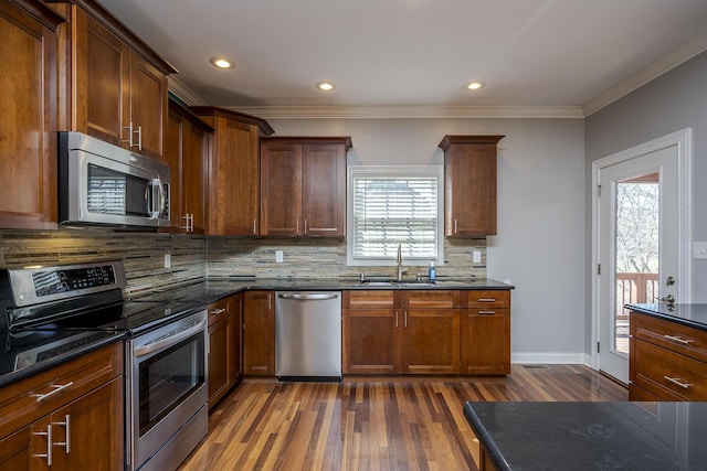 kitchen with decorative backsplash, appliances with stainless steel finishes, dark wood-style flooring, crown molding, and a sink