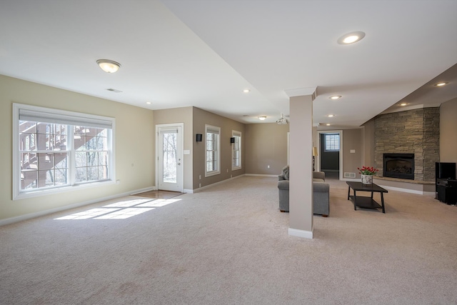 unfurnished living room featuring a stone fireplace, recessed lighting, light carpet, visible vents, and baseboards