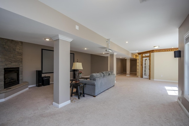 living area with ornate columns, a fireplace, baseboards, and light colored carpet