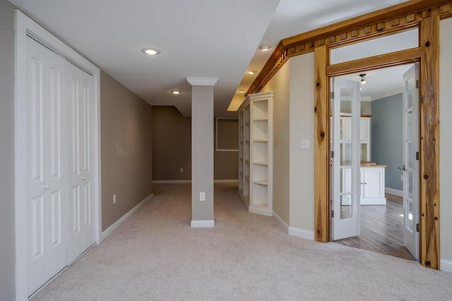 interior space featuring baseboards, ornamental molding, a closet, and light colored carpet