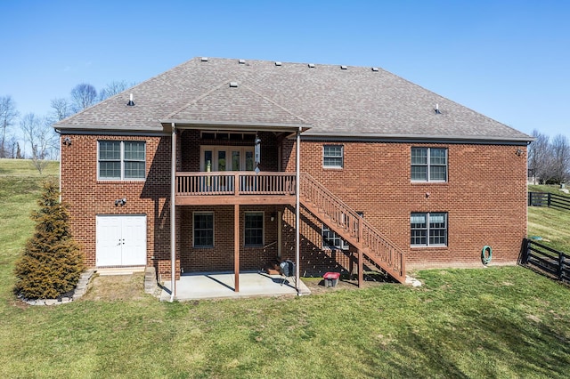 back of house featuring roof with shingles, a lawn, stairway, a patio area, and fence