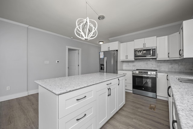 kitchen featuring wood finished floors, appliances with stainless steel finishes, and ornamental molding