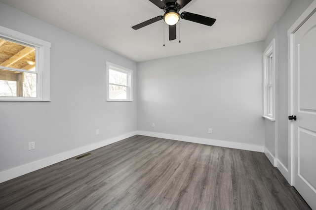 empty room featuring visible vents, wood finished floors, baseboards, and ceiling fan