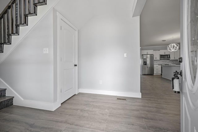 entrance foyer featuring stairs, wood finished floors, visible vents, and baseboards