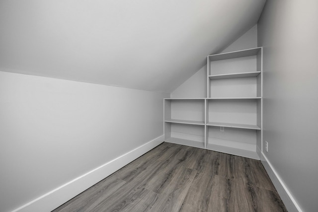 interior space with lofted ceiling, baseboards, and wood finished floors