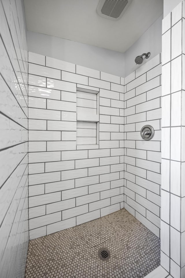 full bathroom featuring visible vents and tiled shower