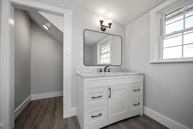 bathroom featuring baseboards, wood finished floors, and vanity