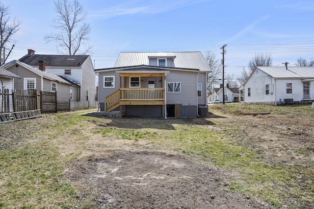 back of property with cooling unit, metal roof, and fence