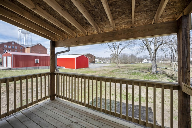 deck featuring an outbuilding and a lawn