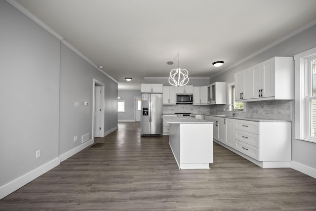 kitchen featuring a sink, stainless steel appliances, backsplash, and white cabinetry