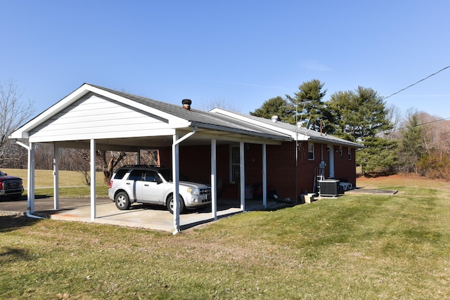 view of side of property with an attached carport, central AC, a yard, and brick siding