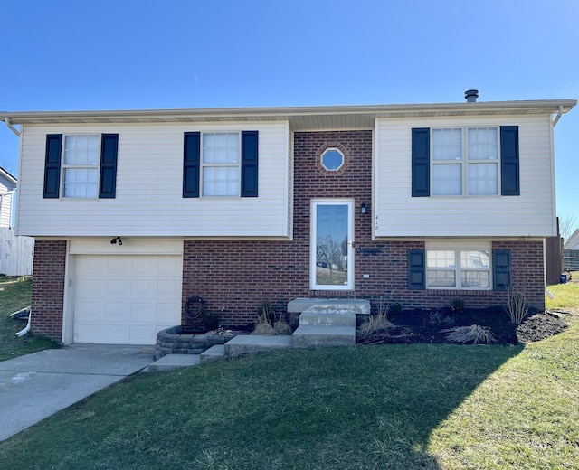 split foyer home featuring an attached garage, a front yard, concrete driveway, and brick siding