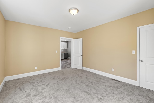 unfurnished room with carpet flooring, visible vents, and baseboards