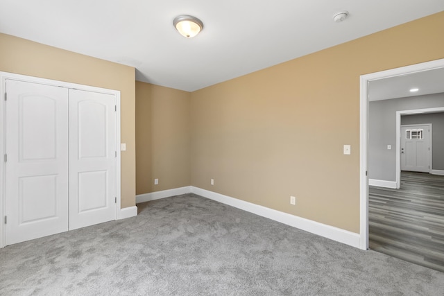 unfurnished bedroom with carpet floors, baseboards, and a closet