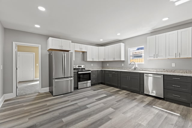 kitchen featuring stainless steel appliances, recessed lighting, a sink, and white cabinets