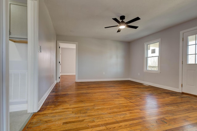 unfurnished room with wood-type flooring, ceiling fan, and baseboards