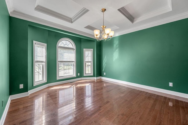 empty room featuring a chandelier, wood-type flooring, coffered ceiling, and baseboards