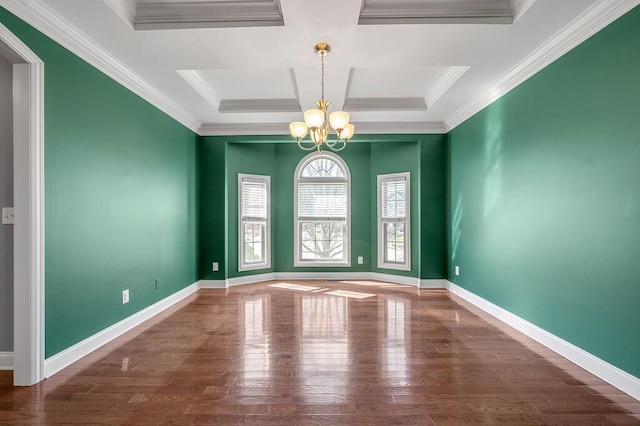 spare room with baseboards, wood finished floors, and a notable chandelier