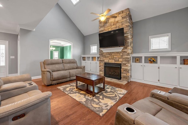 living area with baseboards, a fireplace, high vaulted ceiling, and wood finished floors