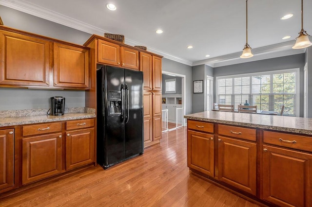 kitchen with ornamental molding, black refrigerator with ice dispenser, and brown cabinetry