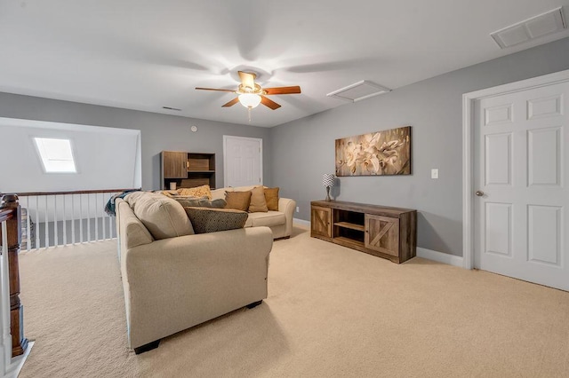 carpeted living area featuring ceiling fan, attic access, visible vents, and baseboards