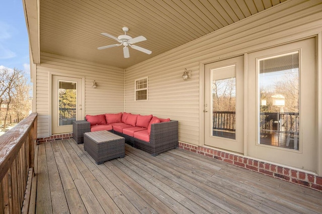 wooden deck featuring outdoor lounge area and ceiling fan