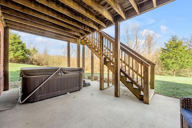 view of patio / terrace with a hot tub and stairway