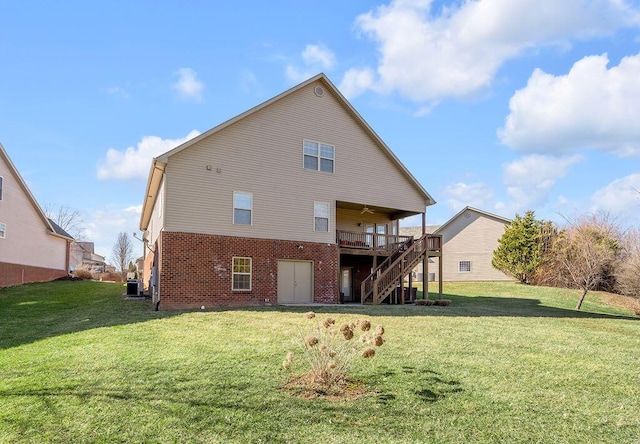 rear view of property featuring brick siding, stairway, and a lawn