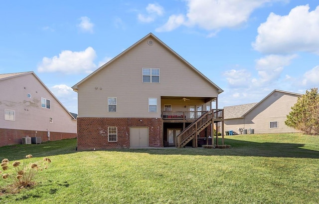 rear view of property with brick siding, stairway, a deck, and a yard