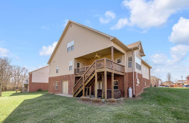 back of house with brick siding, a yard, stairway, a hot tub, and ceiling fan