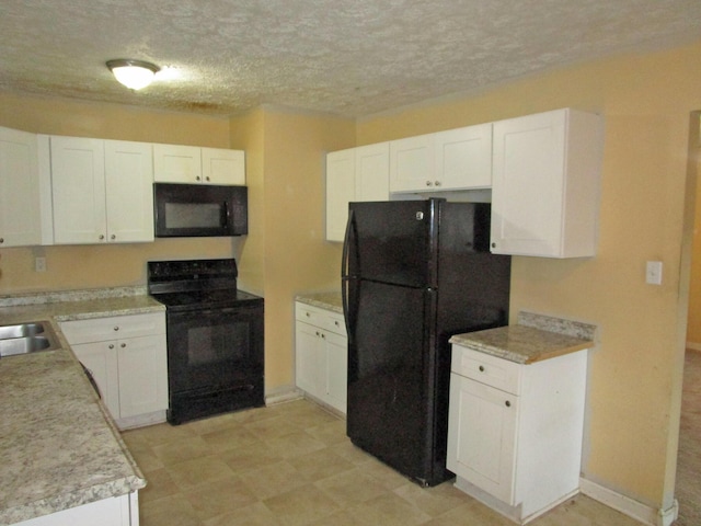 kitchen featuring light countertops, a textured ceiling, black appliances, white cabinetry, and a sink