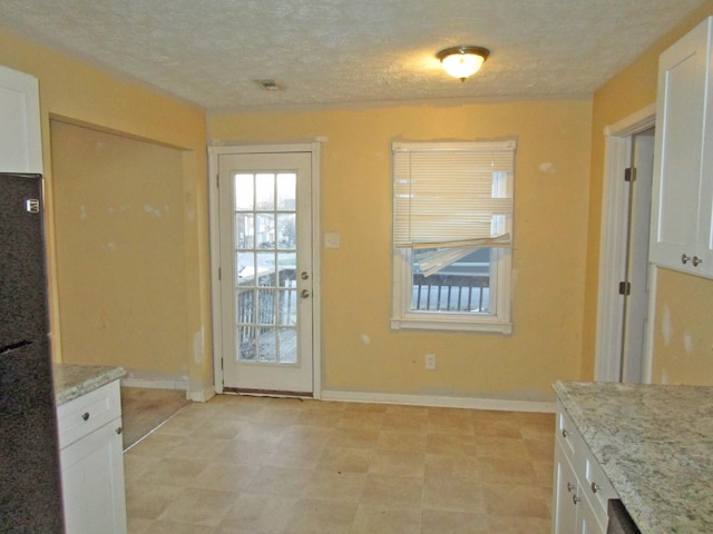 doorway featuring baseboards and a textured ceiling