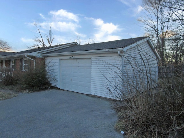 view of property exterior featuring a garage and driveway