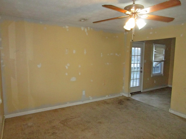 spare room featuring carpet floors, ceiling fan, and baseboards