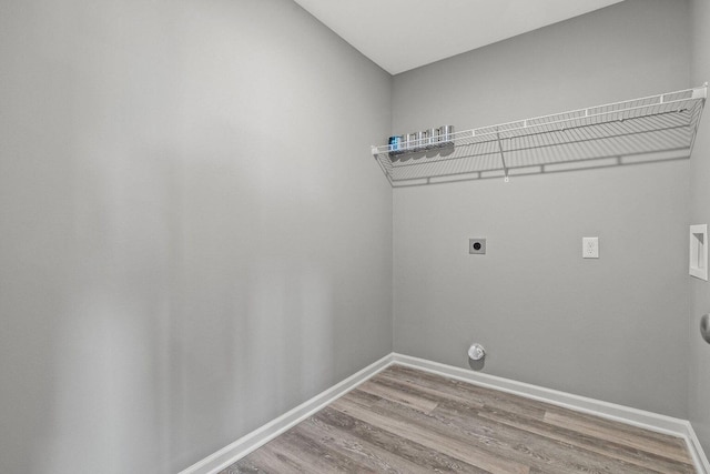 washroom featuring hookup for an electric dryer, laundry area, washer hookup, wood finished floors, and baseboards