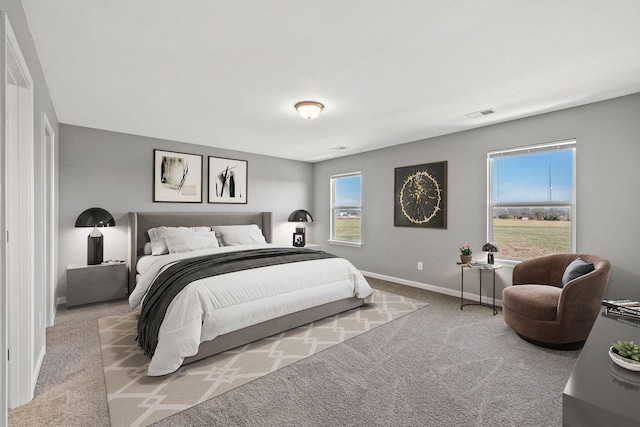 carpeted bedroom with multiple windows, visible vents, and baseboards